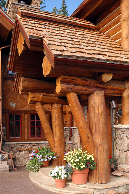 A hybrid log house using large flared timbers for the front entry